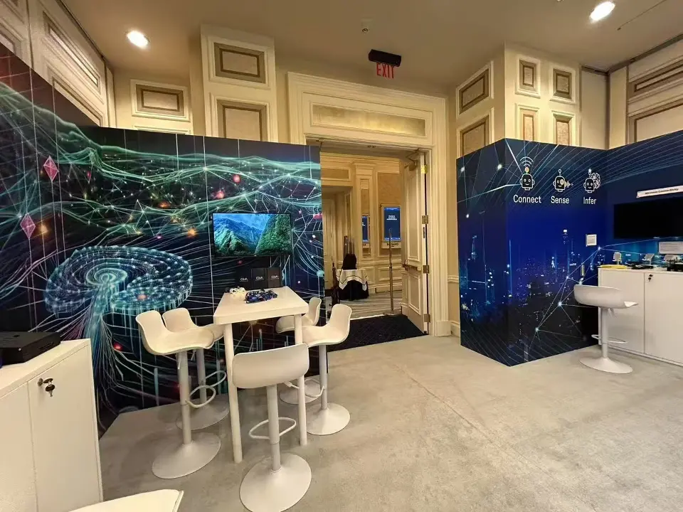 Network-line wall graphics and a Connect, Sense, Infer panel framing white high-top stools in the Ceva suite