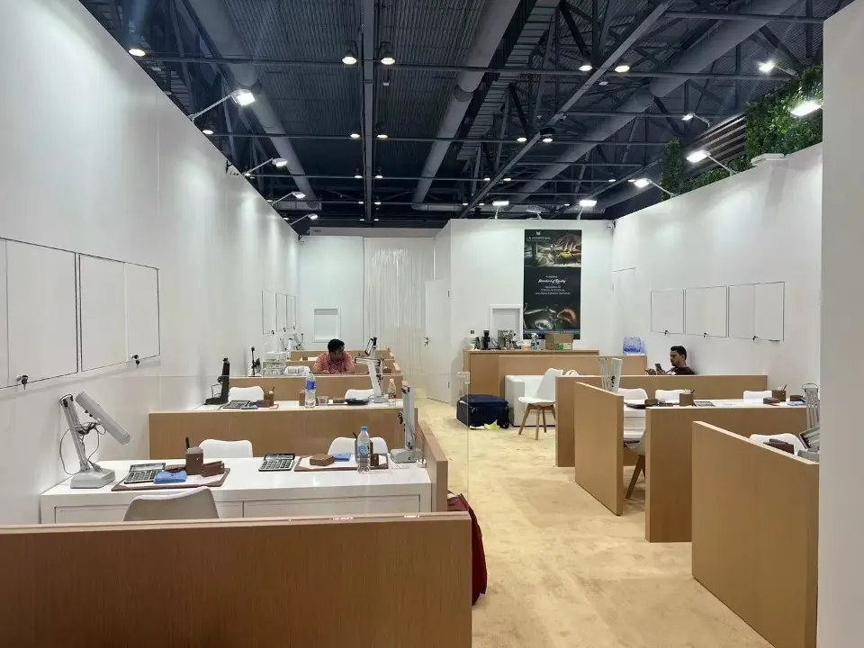 Interior rows of wood-look viewing desks with task lamps and white chairs for private appointments