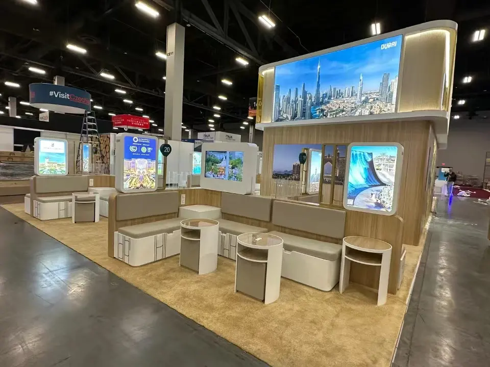 Numbered meeting pods with upholstered benches, round tables and destination lightboxes under a skyline image