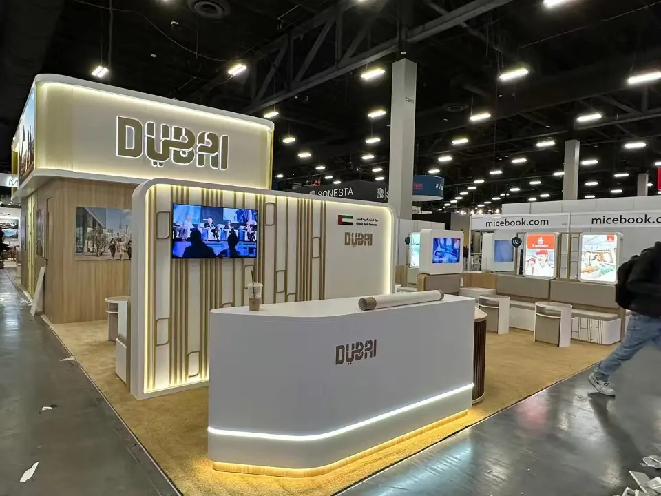 Dubai stand at IMEX America 2023 with illuminated DUBAI fascia and curved reception counter