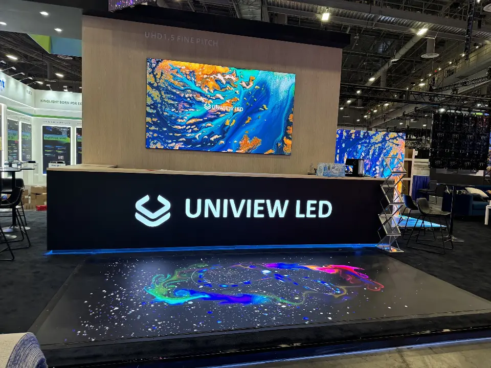 Uniview LED reception counter in front of a large colorful video wall and lit floor display