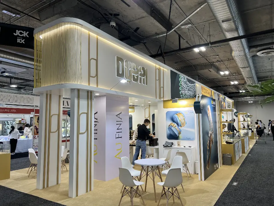 End of the Dubai pavilion with curved lit fascia, Au Finja panels and white meeting chairs