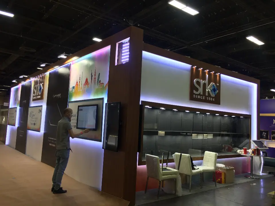 Wider corner view of the booth with showcase and skyline graphic