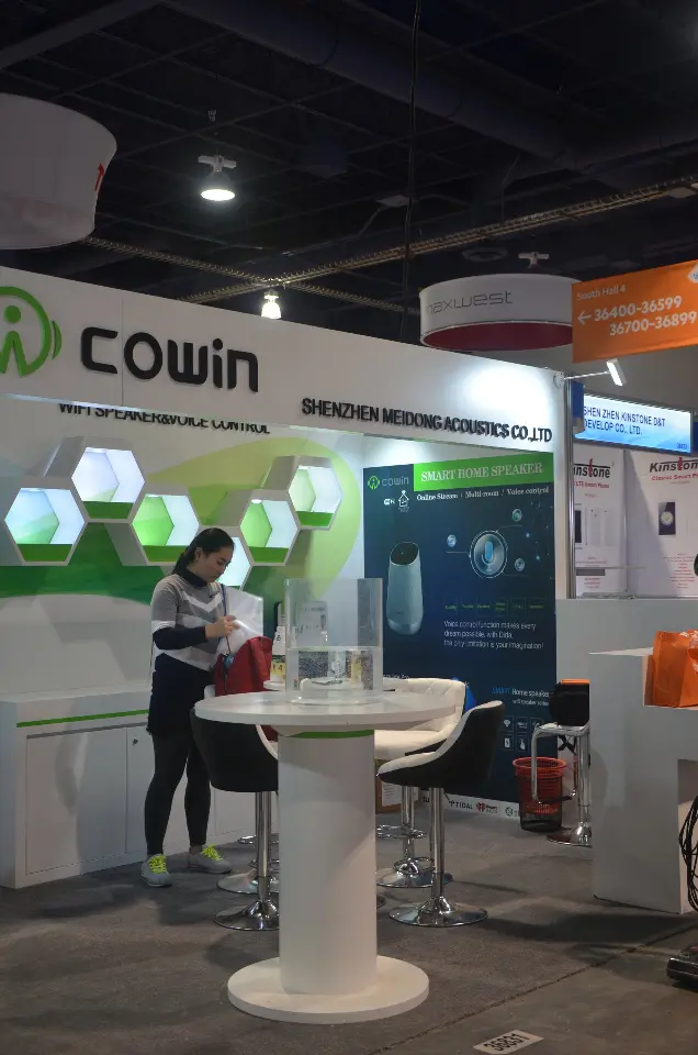 Narrow view of the green hexagon wall and white table at the Cowin booth