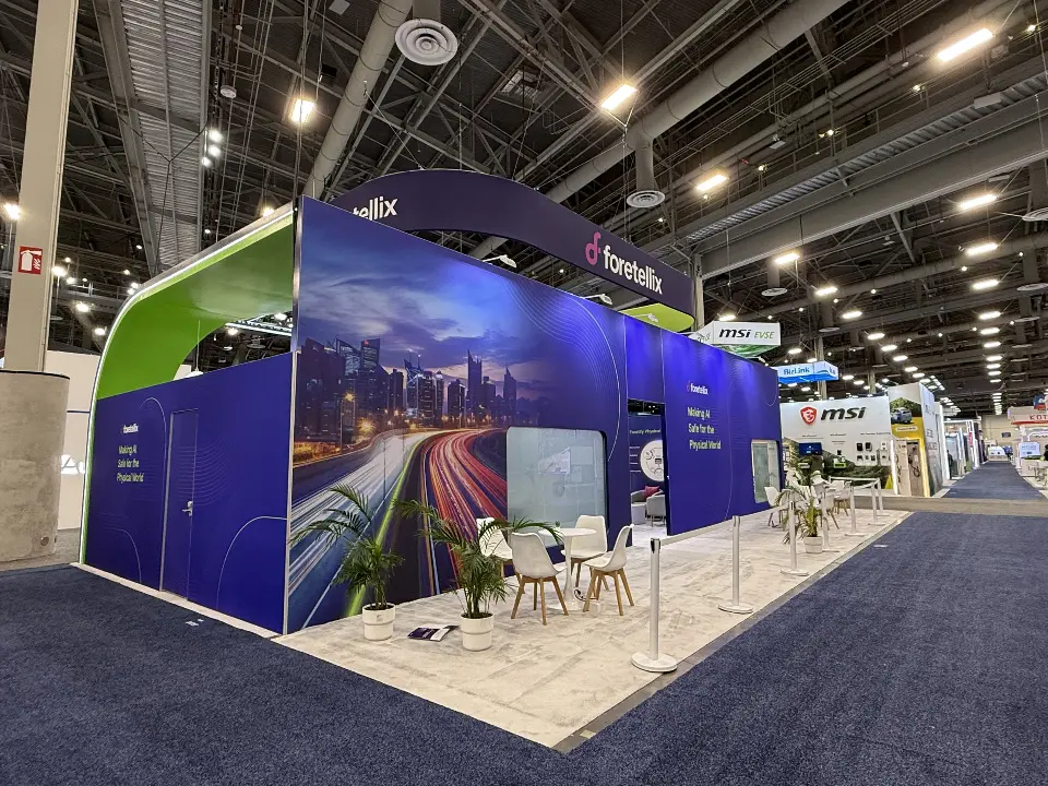 Mural-wrapped corner of the booth seen down the carpeted aisle