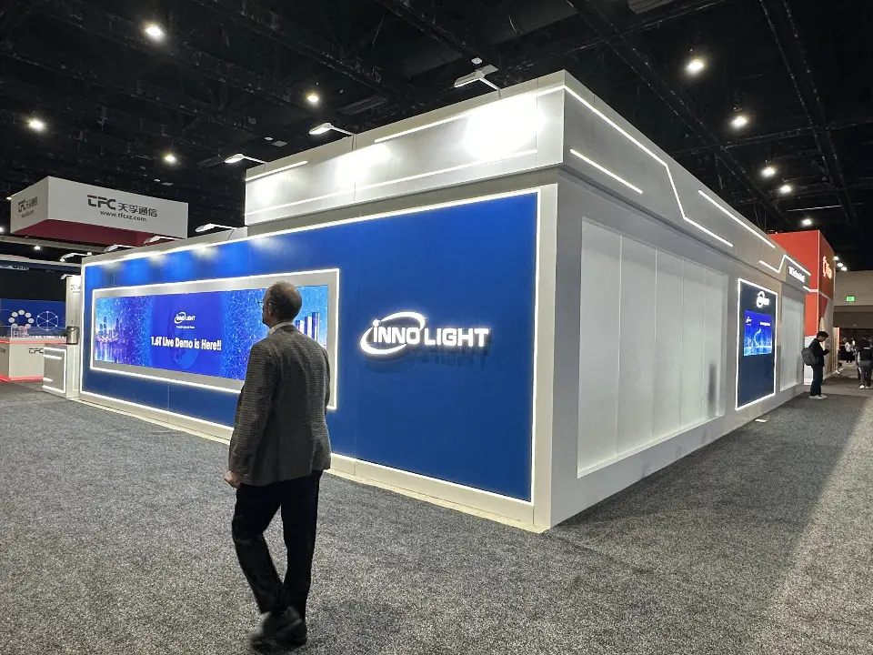 Blue wall with INNO LIGHT logo and long video screen beside frosted panels