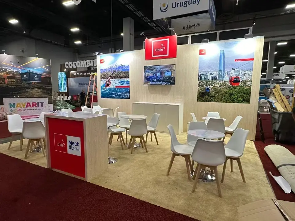 Front view of the Chile stand with red Meet Chile counter and white chairs around round tables