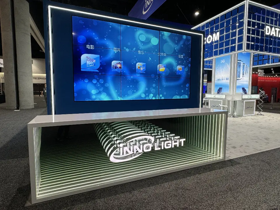 Large video screen above a mirror-tunnel InnoLight logo panel at the booth edge