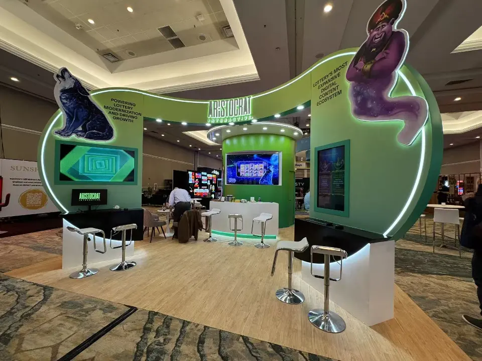 Aristocrat Interactive booth at NASPL 2026 with a lit green arch, wolf and genie cut-outs and lounge seating