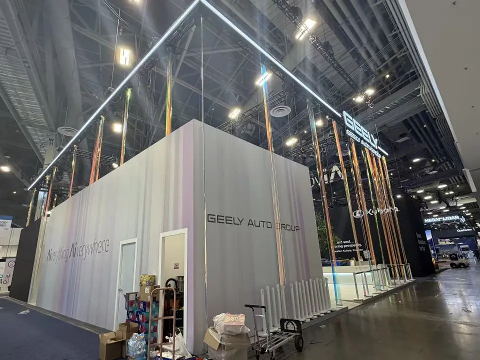 Back of a white wall cube with Geely Auto lettering and stored items