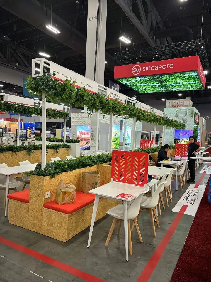 Vertical view of white planters and cafe tables beneath trailing greenery