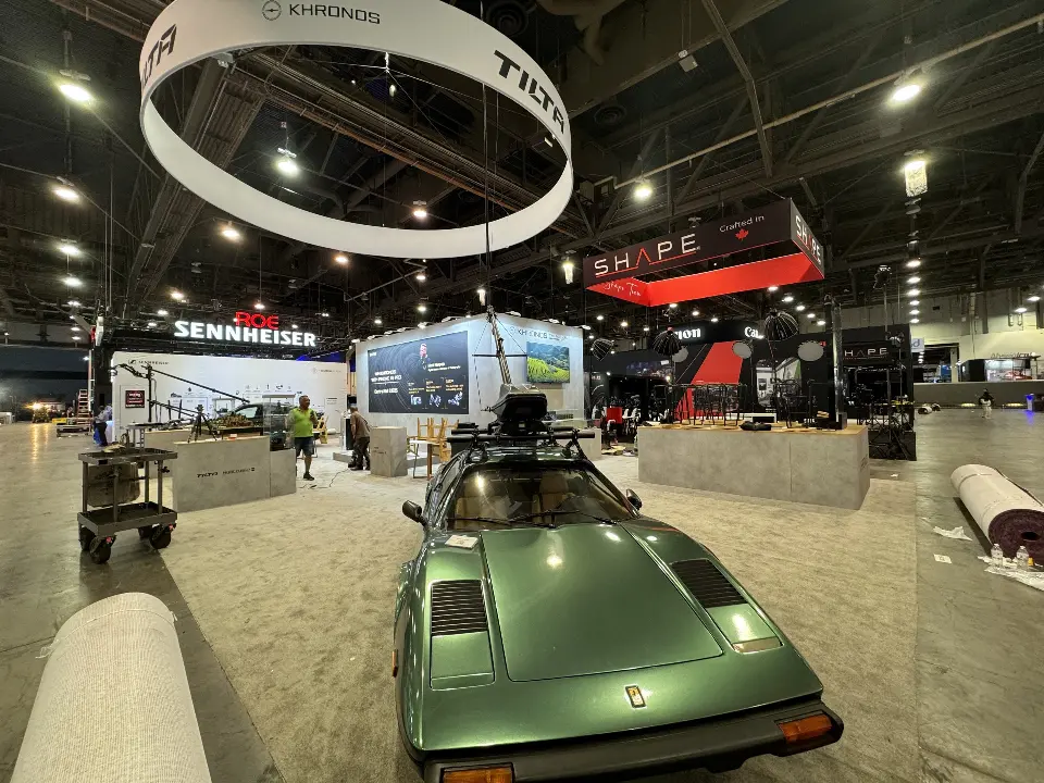 Green classic sports car with roof-mounted rig under the white ring sign