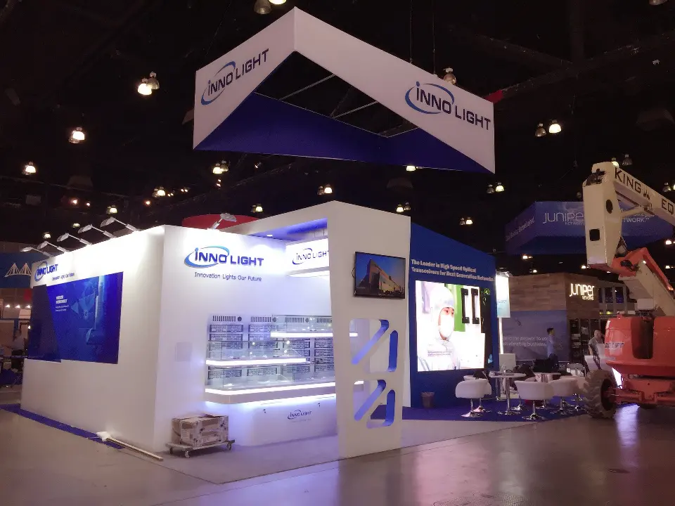 Front of the InnoLight booth with lit glass showcases and blue graphic walls