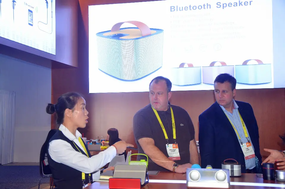 Visitors leaning over the counter while staff present products