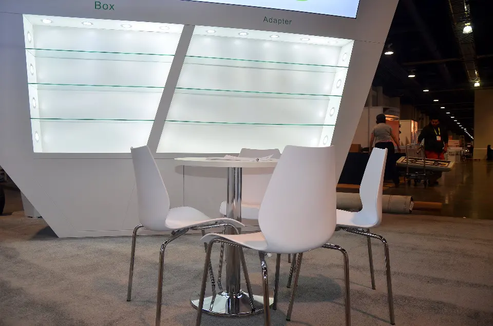 White glass shelves above a small table with white chairs
