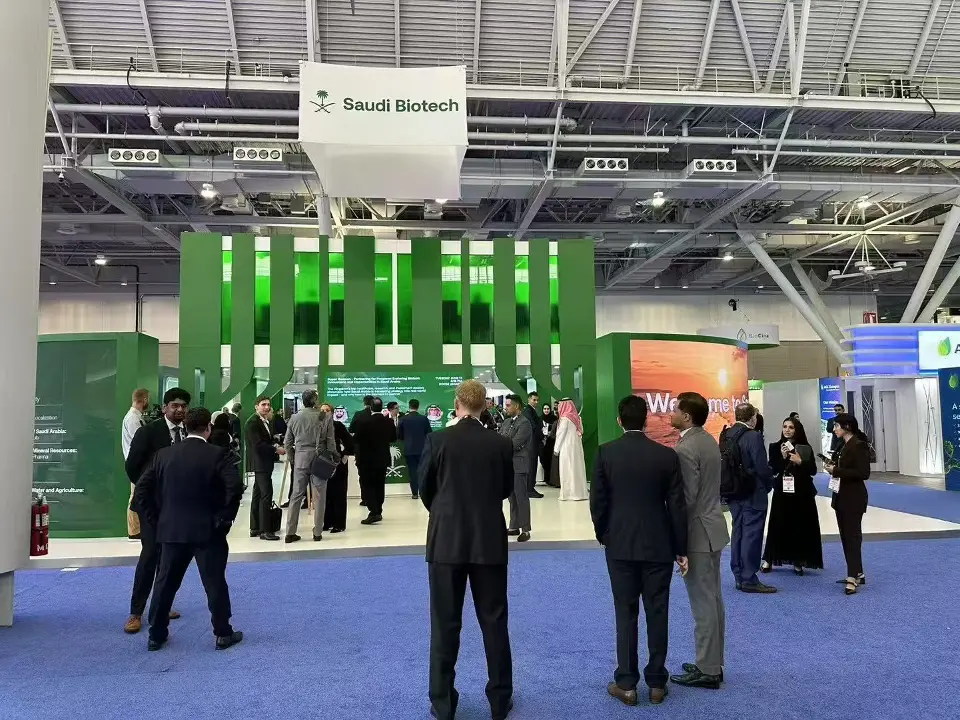 Front view of the green pavilion with guests gathered under the hanging sign