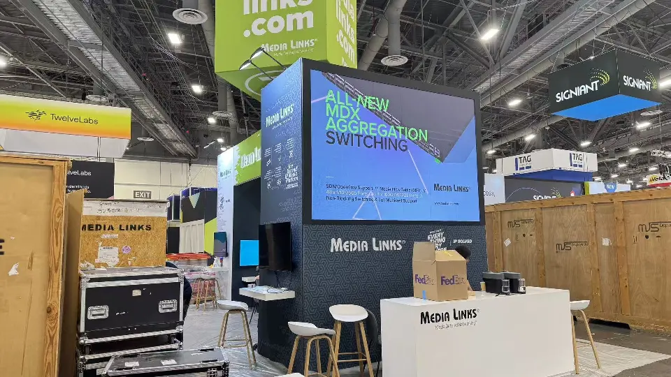 Large video screen above a white Media Links counter with stools