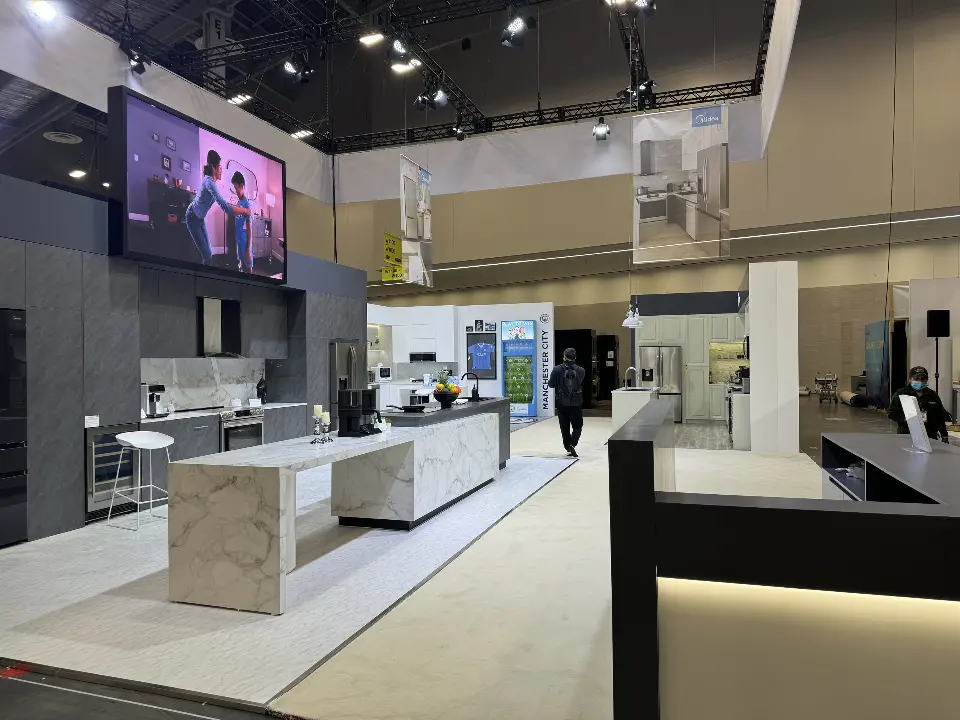 Large screen above a grey kitchen with a marble-look island