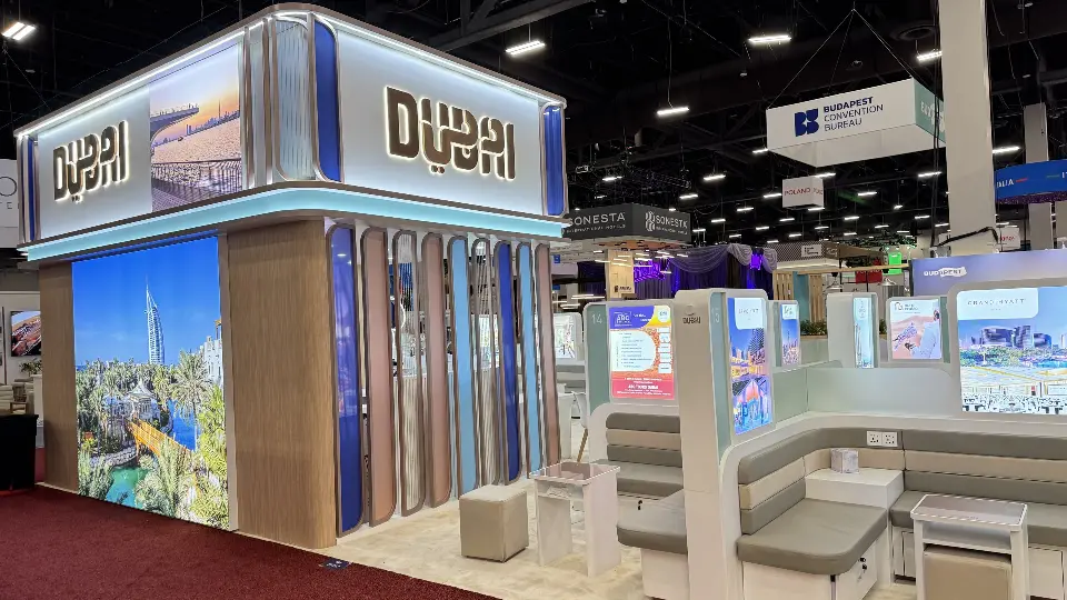 Tall Dubai logo tower with backlit city image and wood-look slats