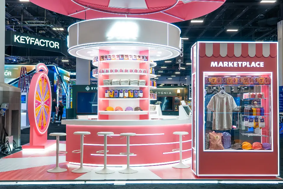 Close view of the AIR merch tower with lit shelves beside the glass-fronted Marketplace kiosk