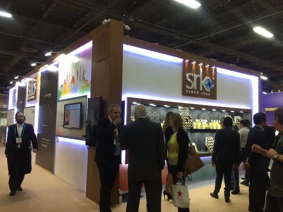 Visitors walking along the side showcases on the open show floor