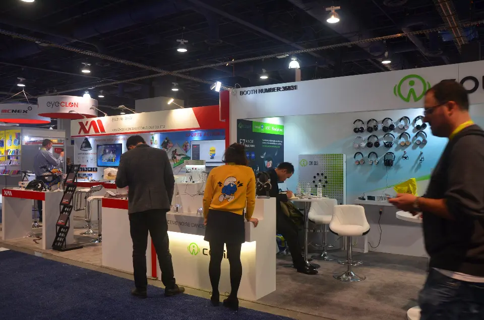 Visitors at the Cowin booth with product shelves and white counters
