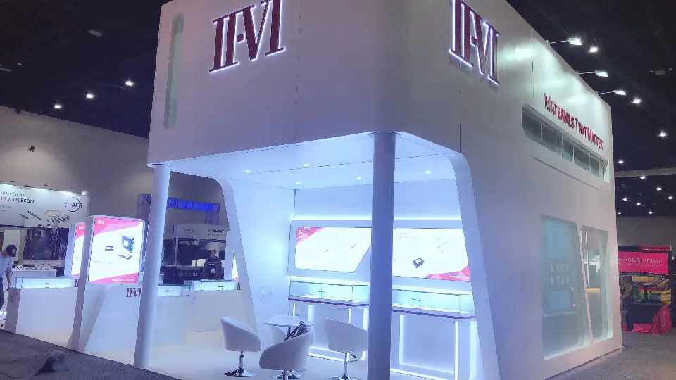 Bright corner of the white booth with frosted glass room and lit display niche