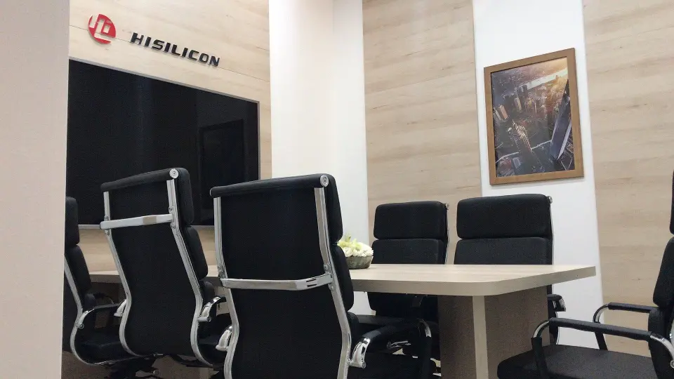 HiSilicon meeting room with black leather chairs, wood-look table and framed art