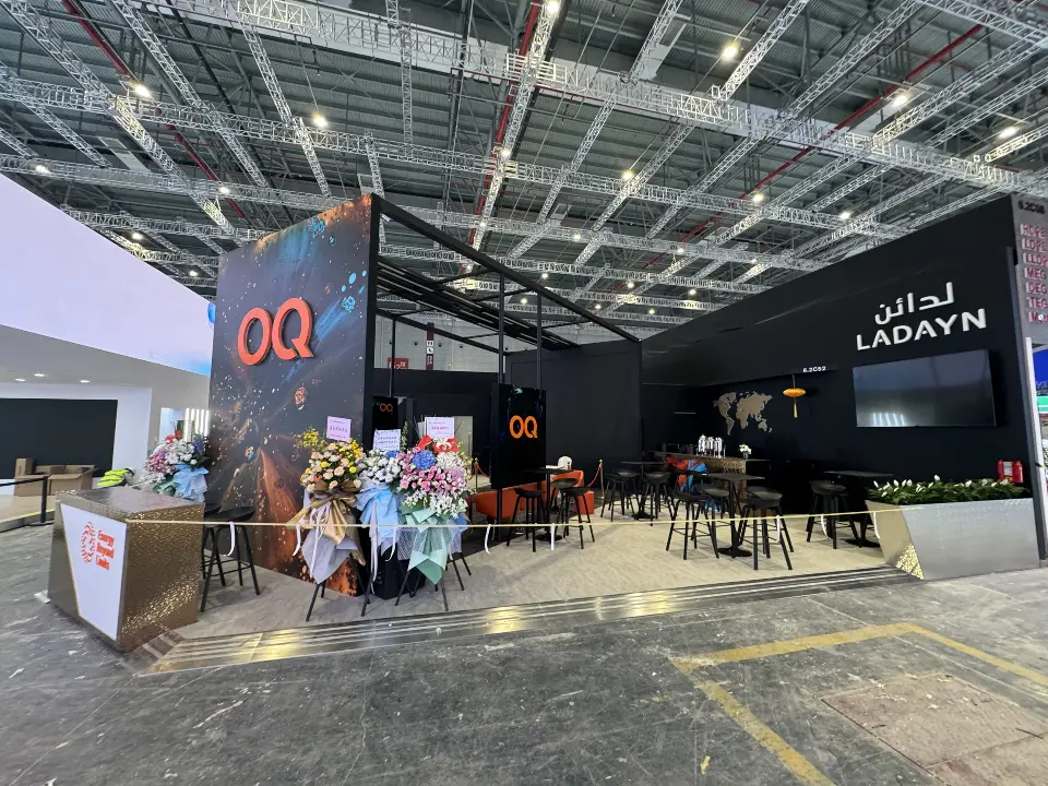 Opposite corner of the OQ tower with the black back wall and lit LADAYN sign