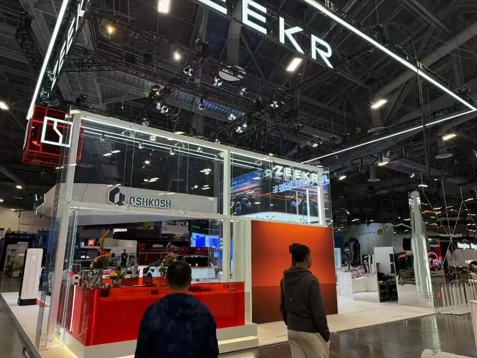 Visitors in front of the glass room and red wall at the ZEEKR booth