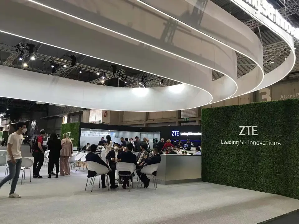 Green wall with ZTE logo and guests seated at a table nearby