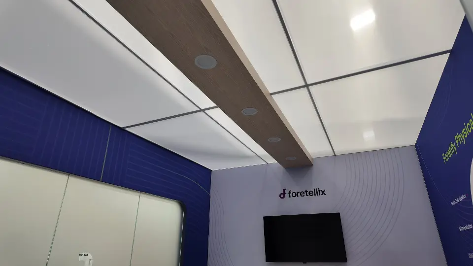 Meeting room ceiling with a wood-look beam above the wall screen