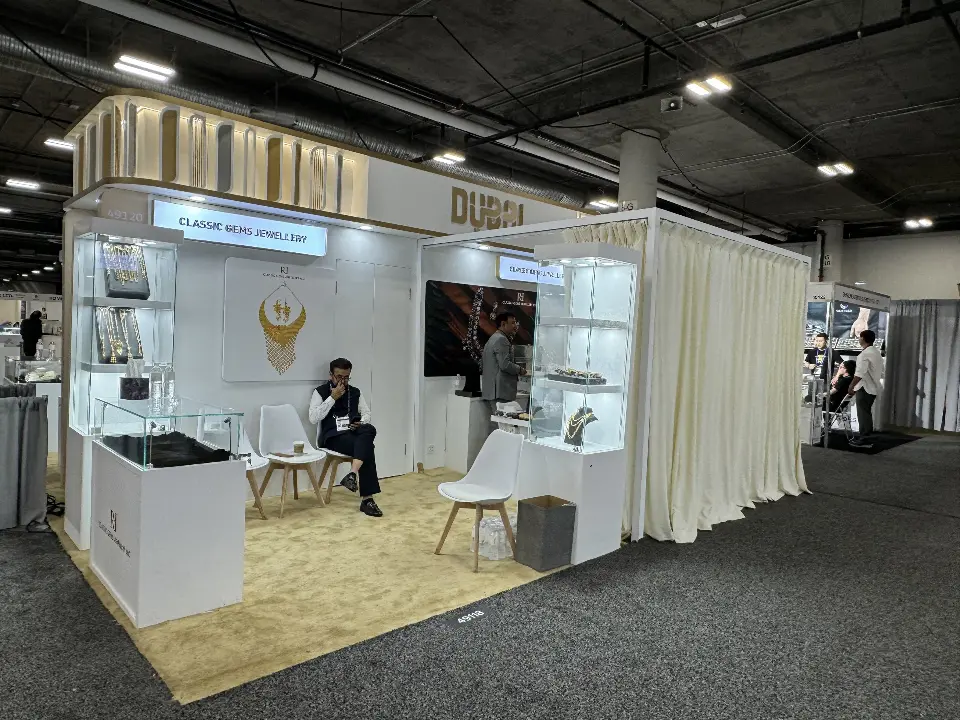 Stand with draped curtains, lit showcases and lounge seating