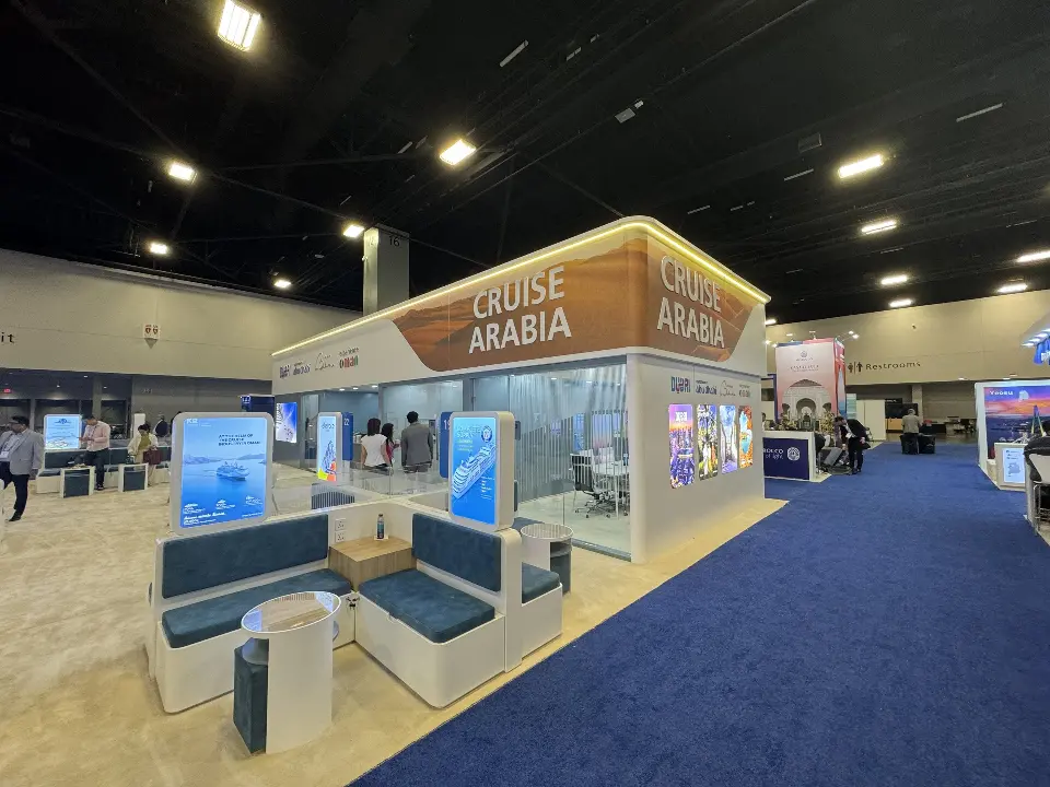 Booth corner with blue lounge pods, backlit posters and the CRUISE ARABIA header