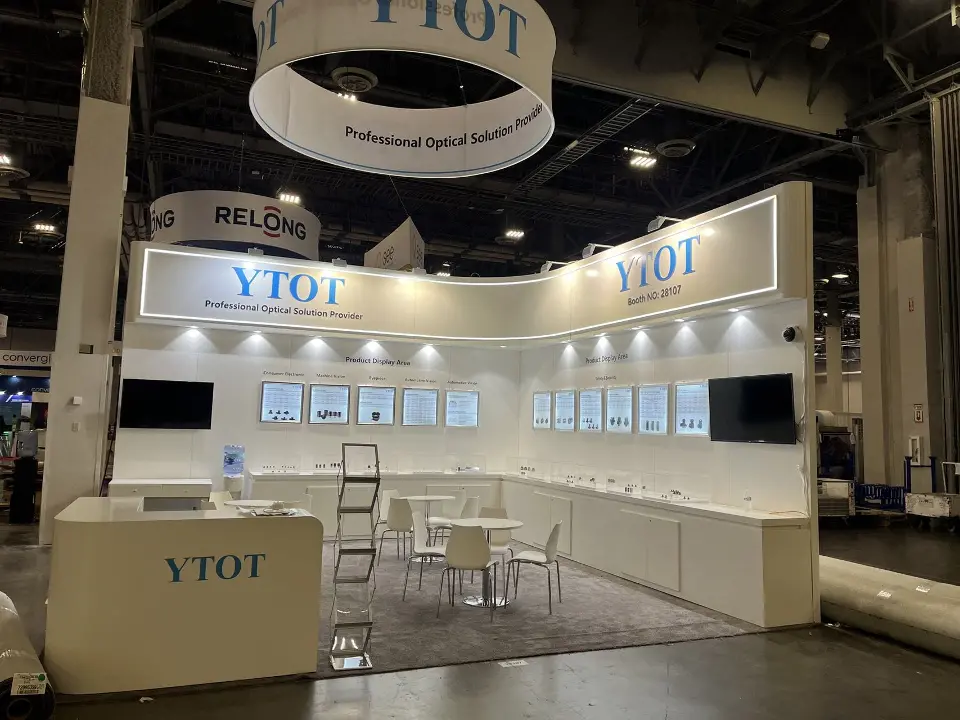 YTOT booth with round hanging sign, backlit product panels and white counter