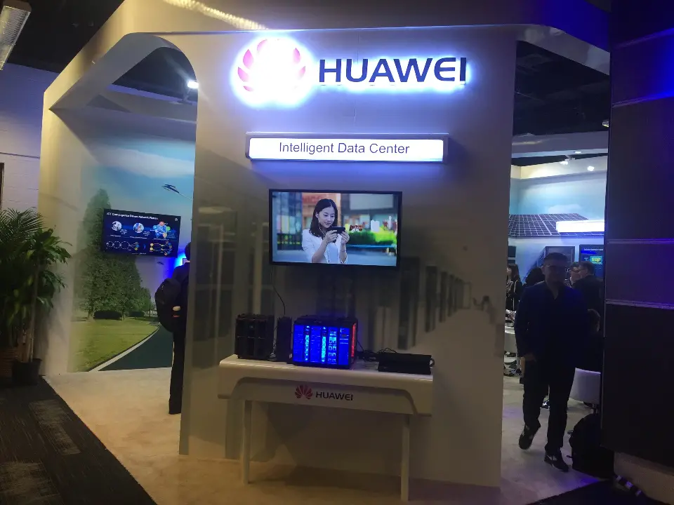Close front view of the Huawei logo, wall screen and equipment display table
