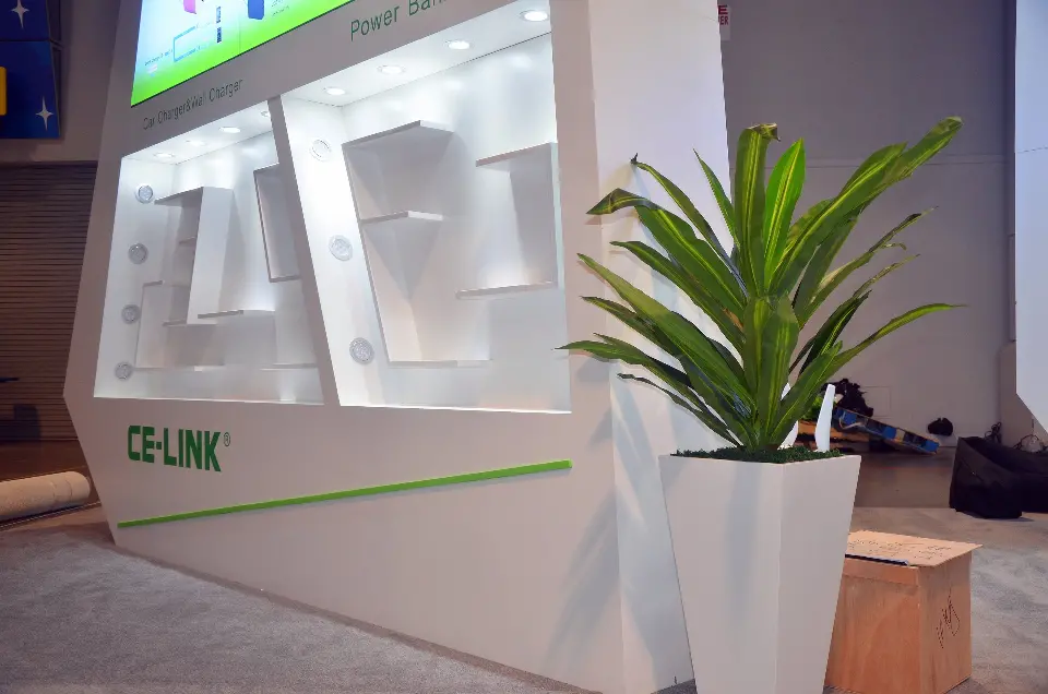 Close-up of backlit shelf niches and a potted plant beside the CE-LINK wall