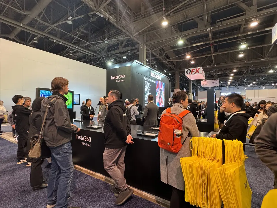 Crowd around a black counter next to a stand of yellow bags