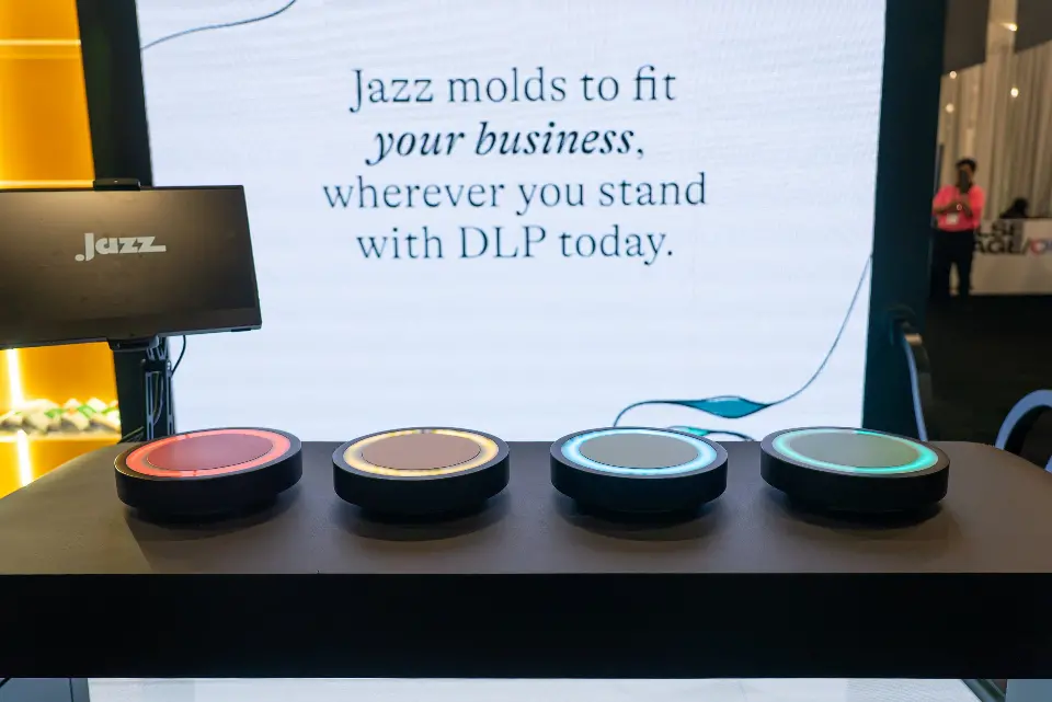 Four lit buttons on a game console in front of a Jazz message panel