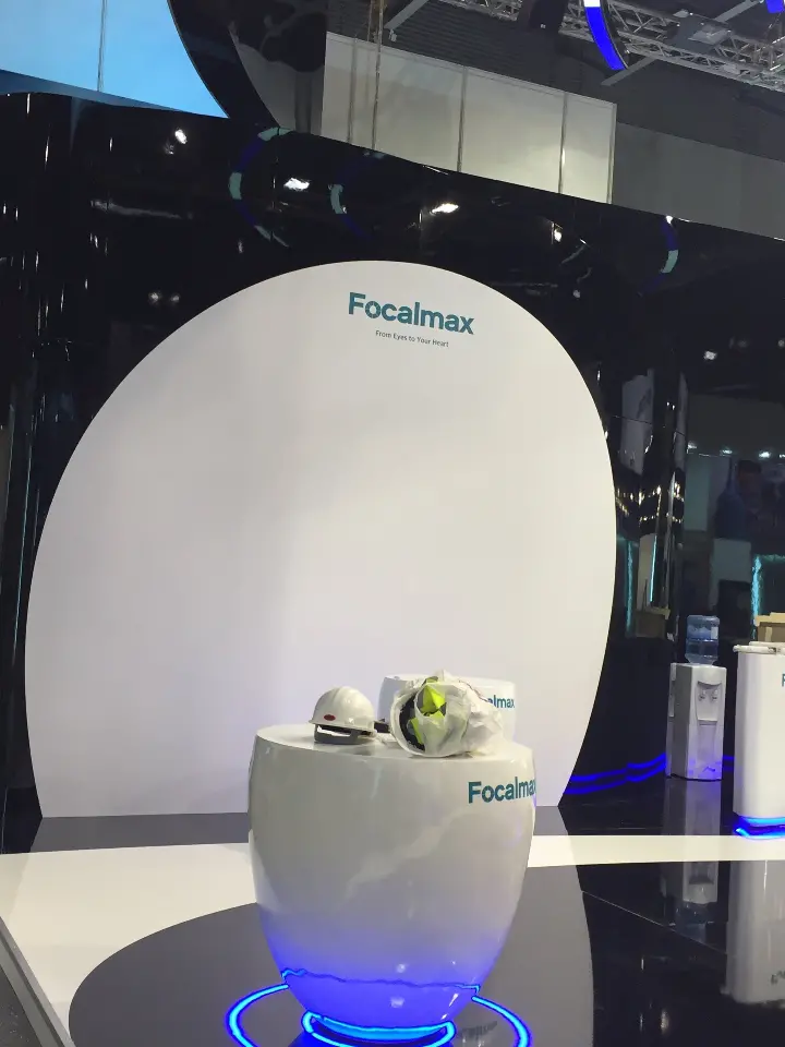 Portrait view of a white Focalmax pod with a round display table and blue base light