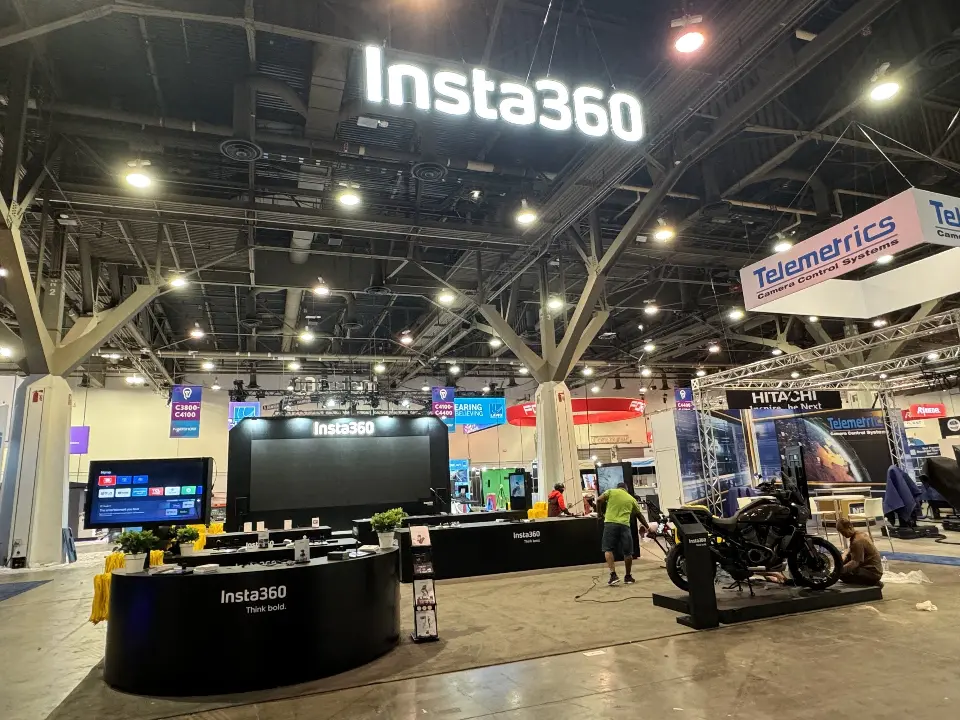 Insta360 sign hanging over black counters, screens and a motorbike display