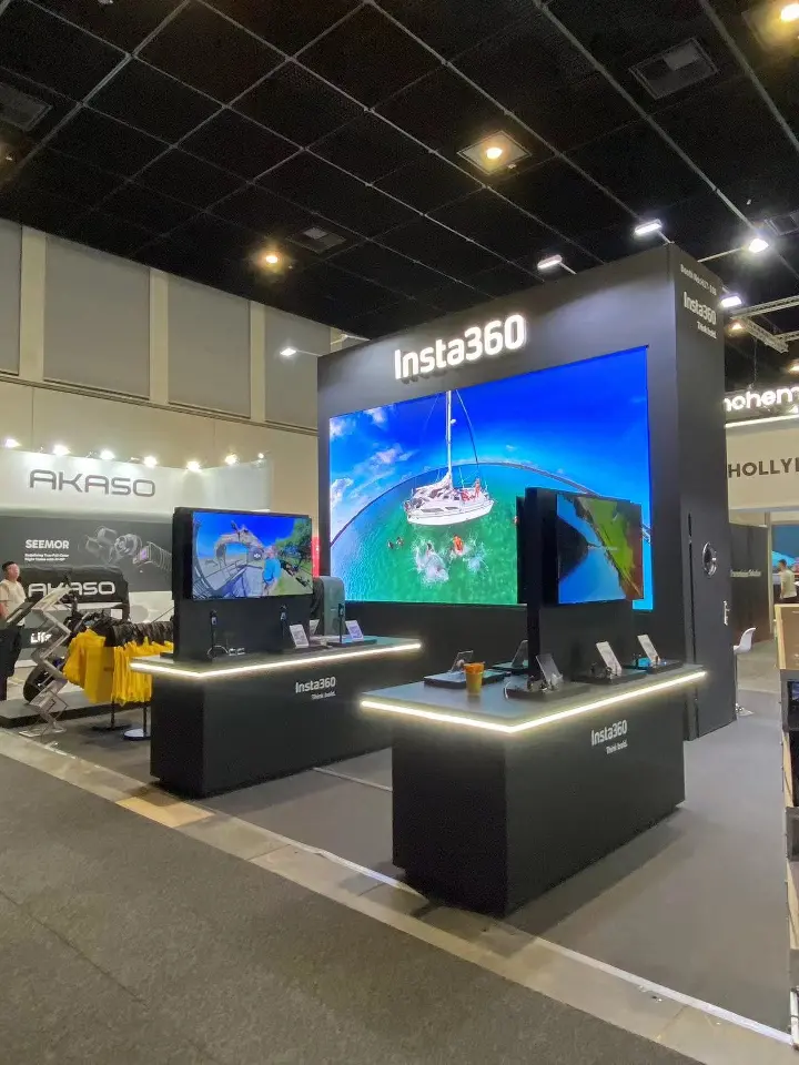 Black Insta360 counters with lit edges and a large video screen behind them