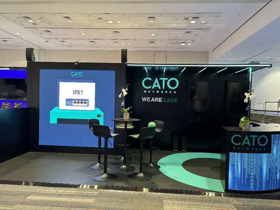 Front view of large video screen, high tables and CATO WE ARE SASE wall