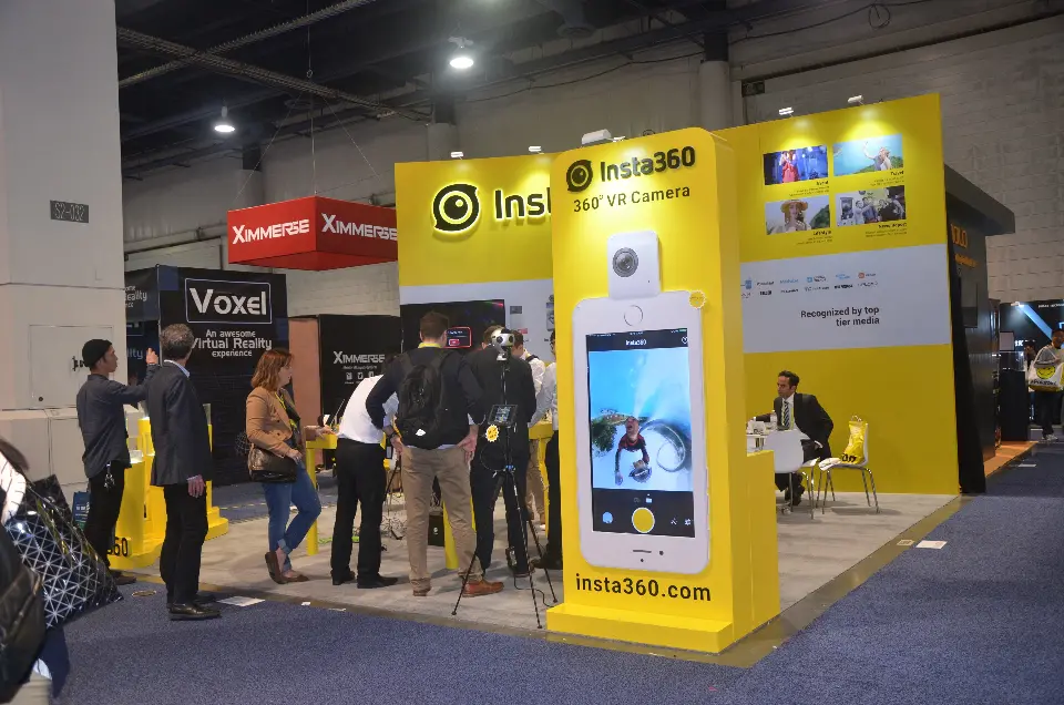 Insta360 booth at CES 2017 with an oversized phone-shaped display tower and yellow back wall