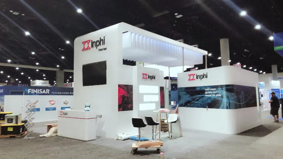 White Inphi booth with lit slatted canopy, dark graphic band and high tables