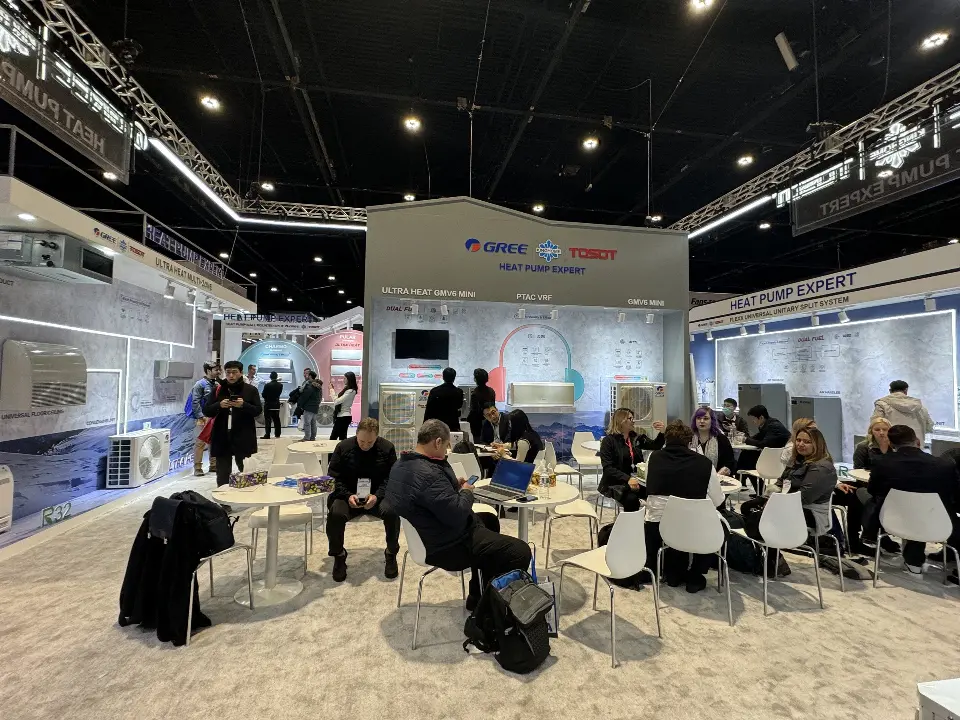 Meeting lounge filled with visitors at white tables under the truss