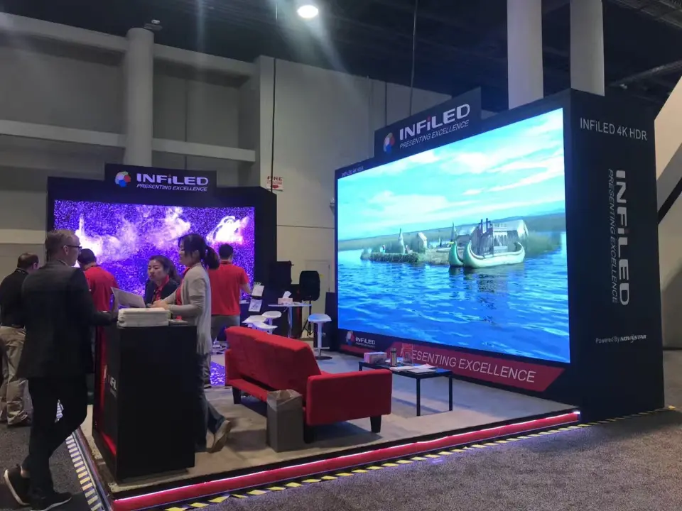 INFiLED corner with a large harbour scene on screen and red sofas in front