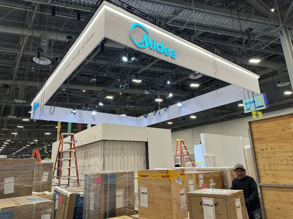 During installation: ladders and crates under the Midea frame as crews work