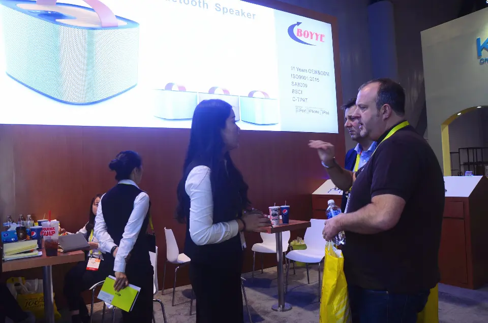 Conversation by the speaker lightbox with visitors holding bags
