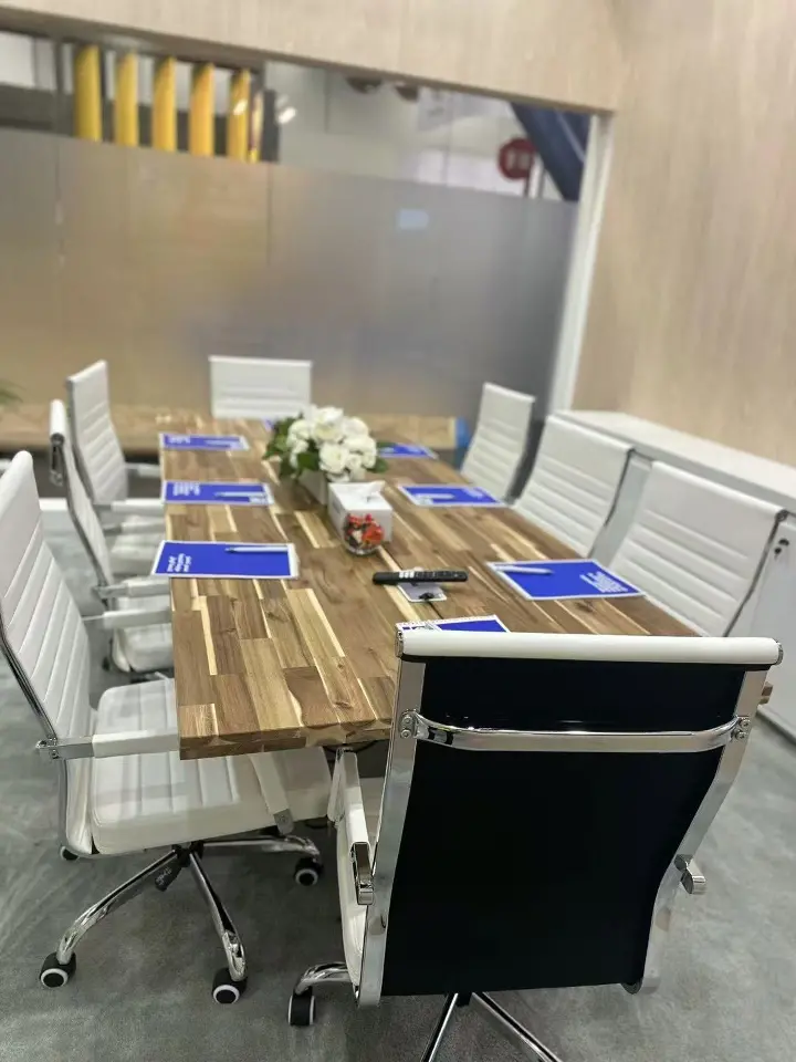 Meeting room with a wood-look table, white chairs and tablets
